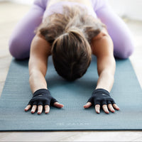 Person in Childs Pose wearing the Gaiam Grippy Yoga Gloves